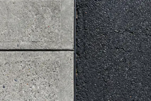 Concrete and asphalt surfaces meeting side by side